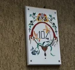 Targa dell'appartamento con scritto 104, all'esterno